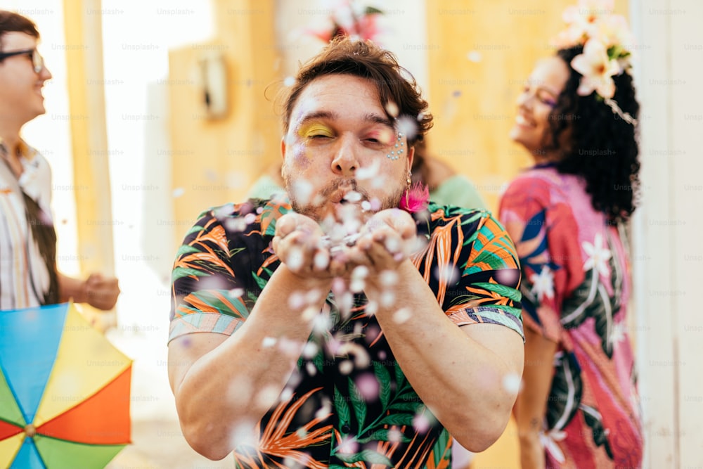 Carnaval brésilien. Jeune homme profitant de la fête de carnaval soufflant des confettis