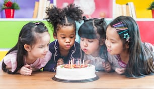 Gruppenvielfalt Kinder blasen Geburtstagskuchen.