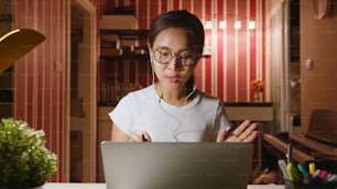 Asiatische Geschäftsfrau arbeitet von zu Hause aus in der Nacht Überstunden, Videokonferenz oder virtuelles Meeting auf Laptop-Computer