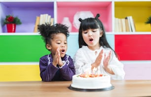 誕生日のケーキを吹くグループの多様性の子供たち。