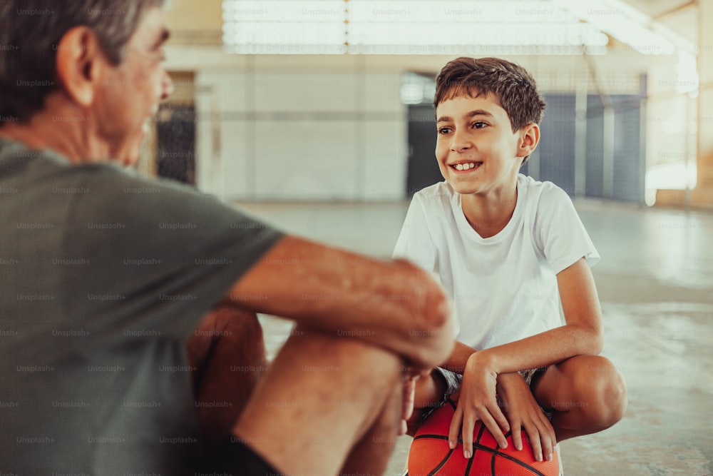 Abuelo y nieto latinos jugando baloncesto en la cancha