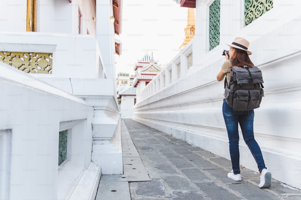 Mujer asiática viaja a Bangkok, Tailandia, en un hermoso templo durante la temporada de verano, tomando fotos con la cámara