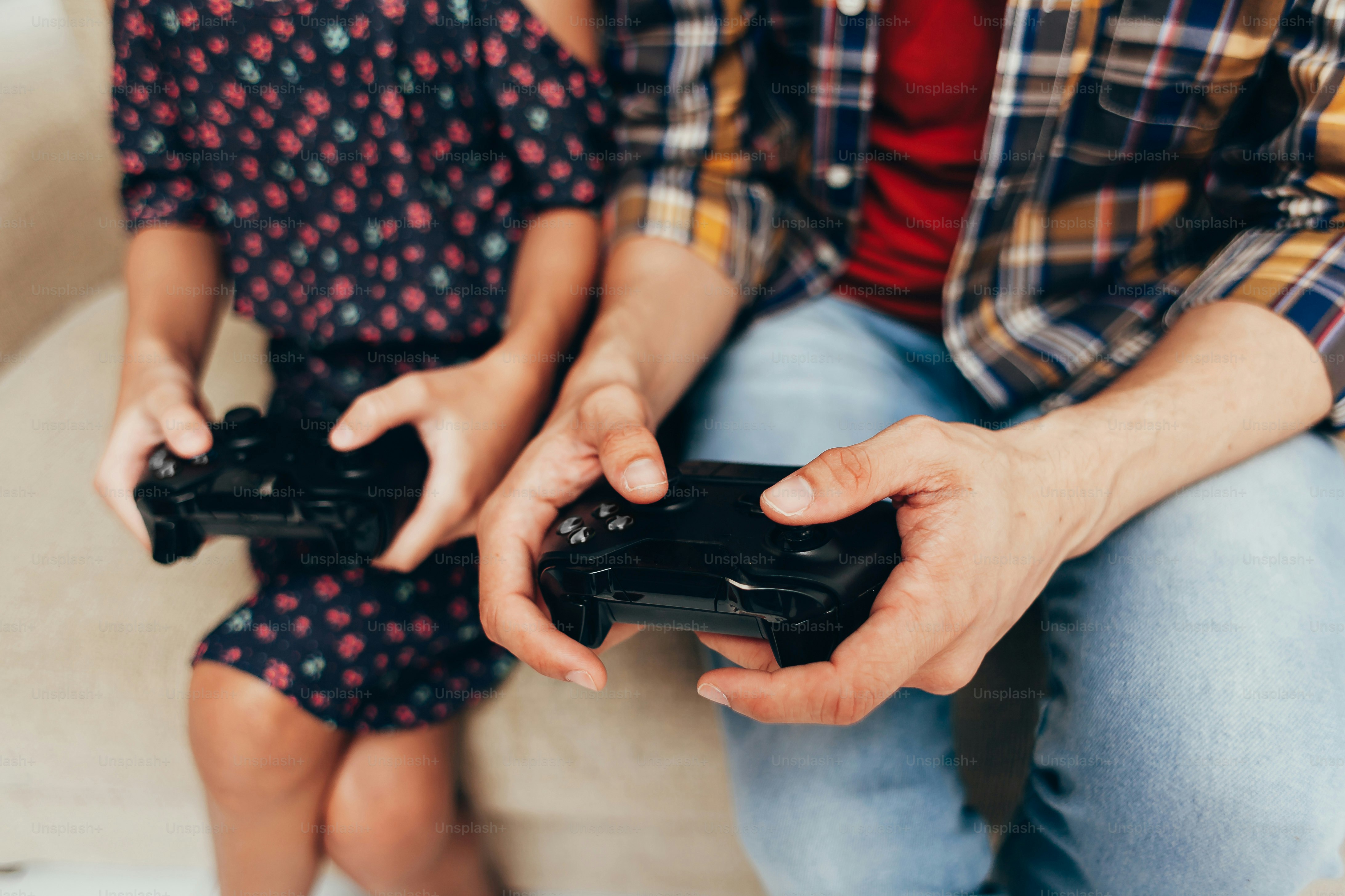 Smiling father and daughter playing video game at home