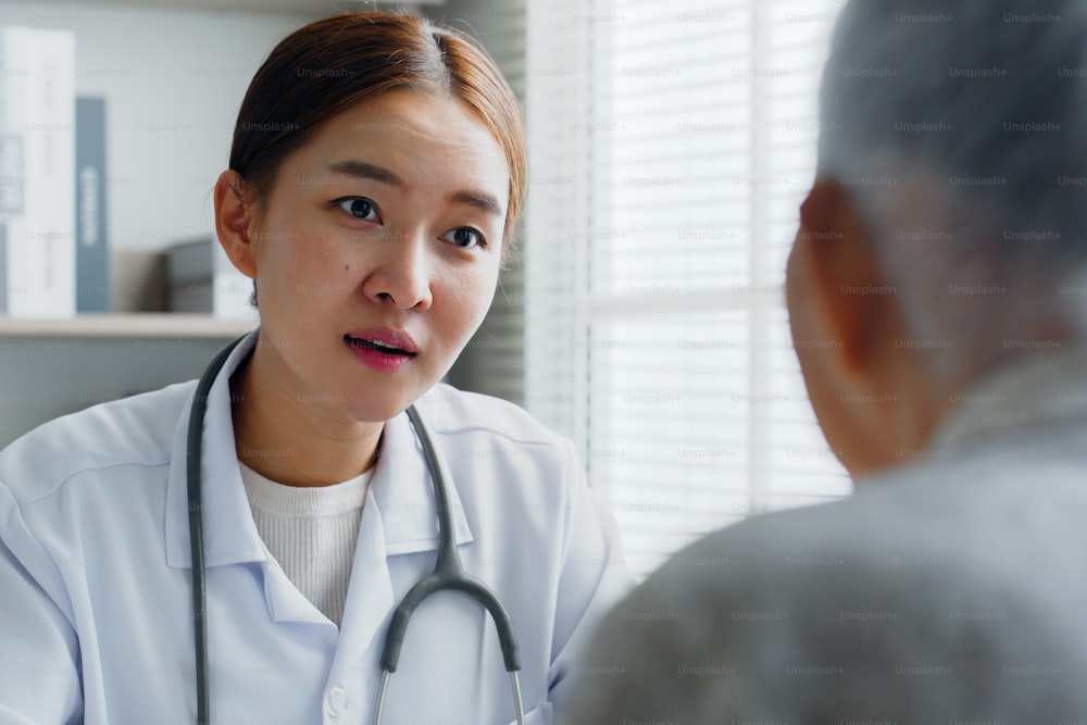 Asian doctor giving consulting with senior old woman patient in medical office, hospital, medical concept