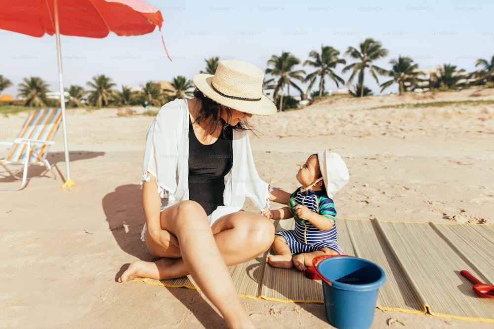 Madre e suo figlio che giocano sulla spiaggia durante le vacanze estive