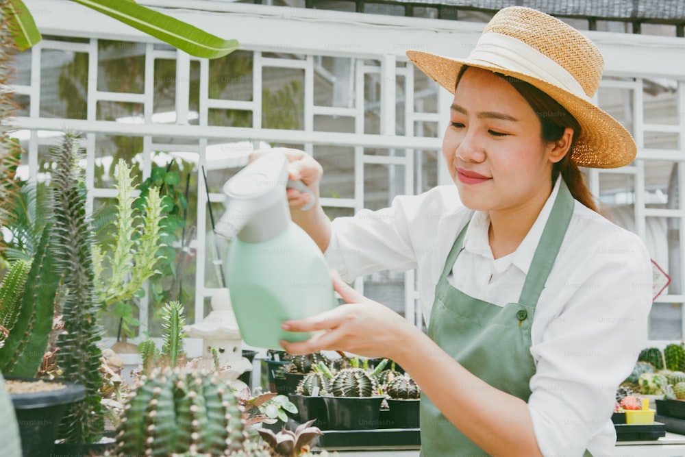 Young Asian woman SME small business entrepreneur water the plant in cactus farm
