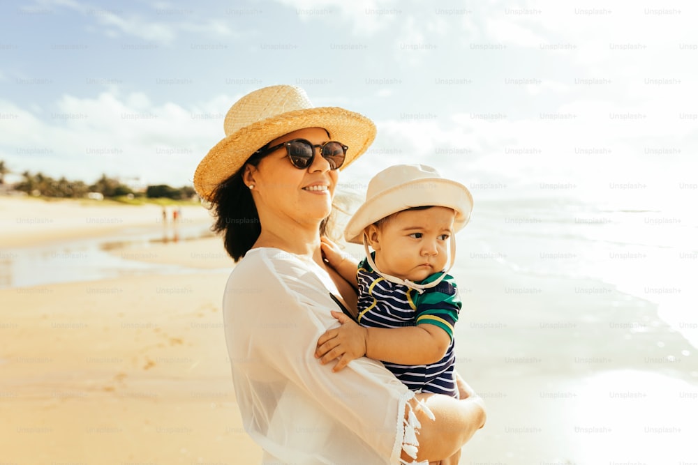 Mother and her baby son playing on the beach during summer vacation