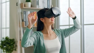 Jovem asiática que se sente animada ao usar o fone de ouvido 360 VR para realidade virtual, metaverso em casa