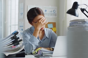 Probó que un joven empleado de oficina asiático se siente enfermo y tiene dolor de cabeza por un largo día de trabajo en la oficina
