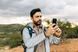 Hombre caminando y tomando fotos con teléfono inteligente en Caatinga brasileña