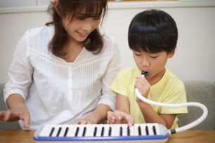 Genitori e bambini che si esercitano con l'armonica a tastiera
