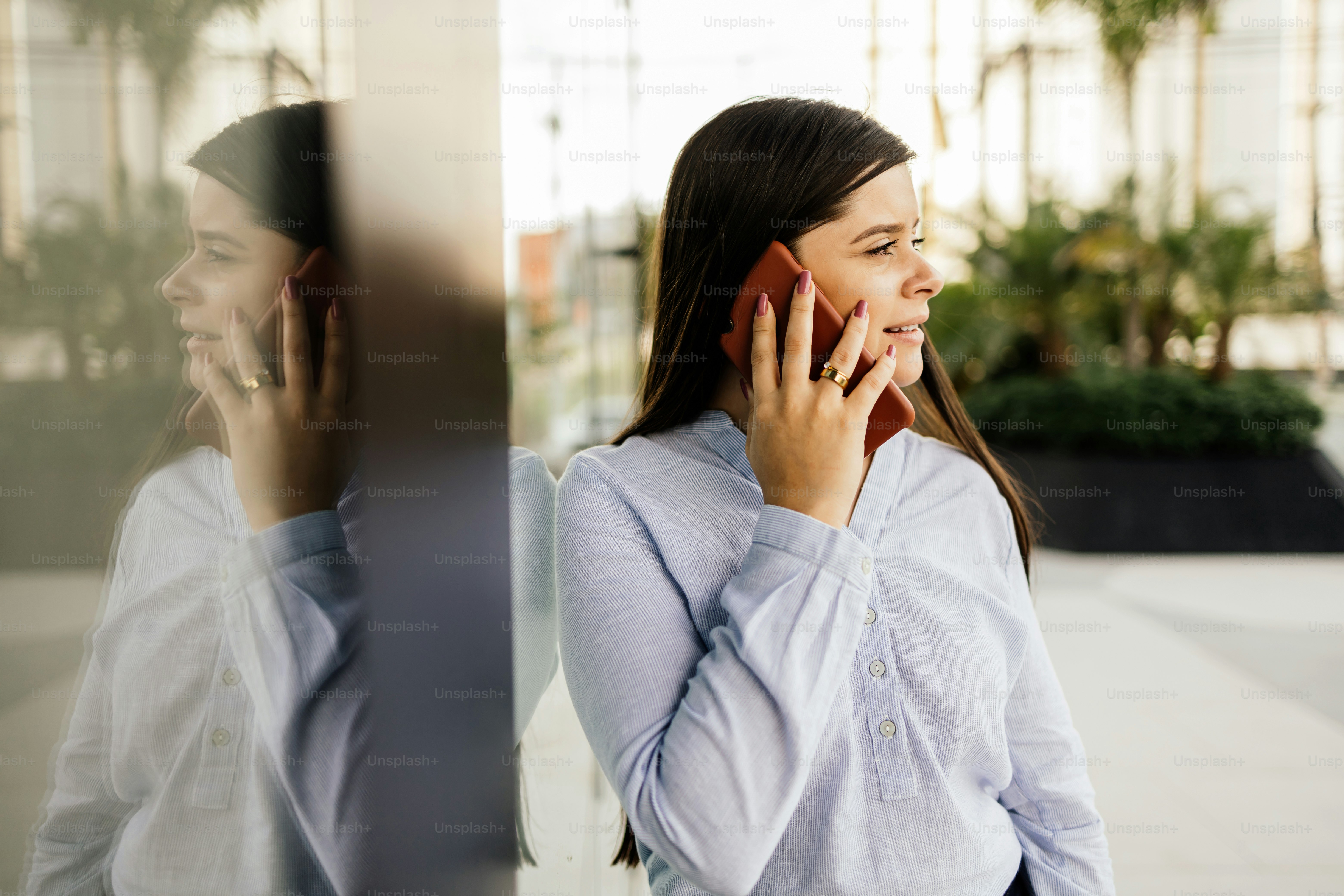 Young businesswoman using smartphone in downtown streets near business buildings