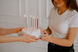 a woman holding a cake with candles on it