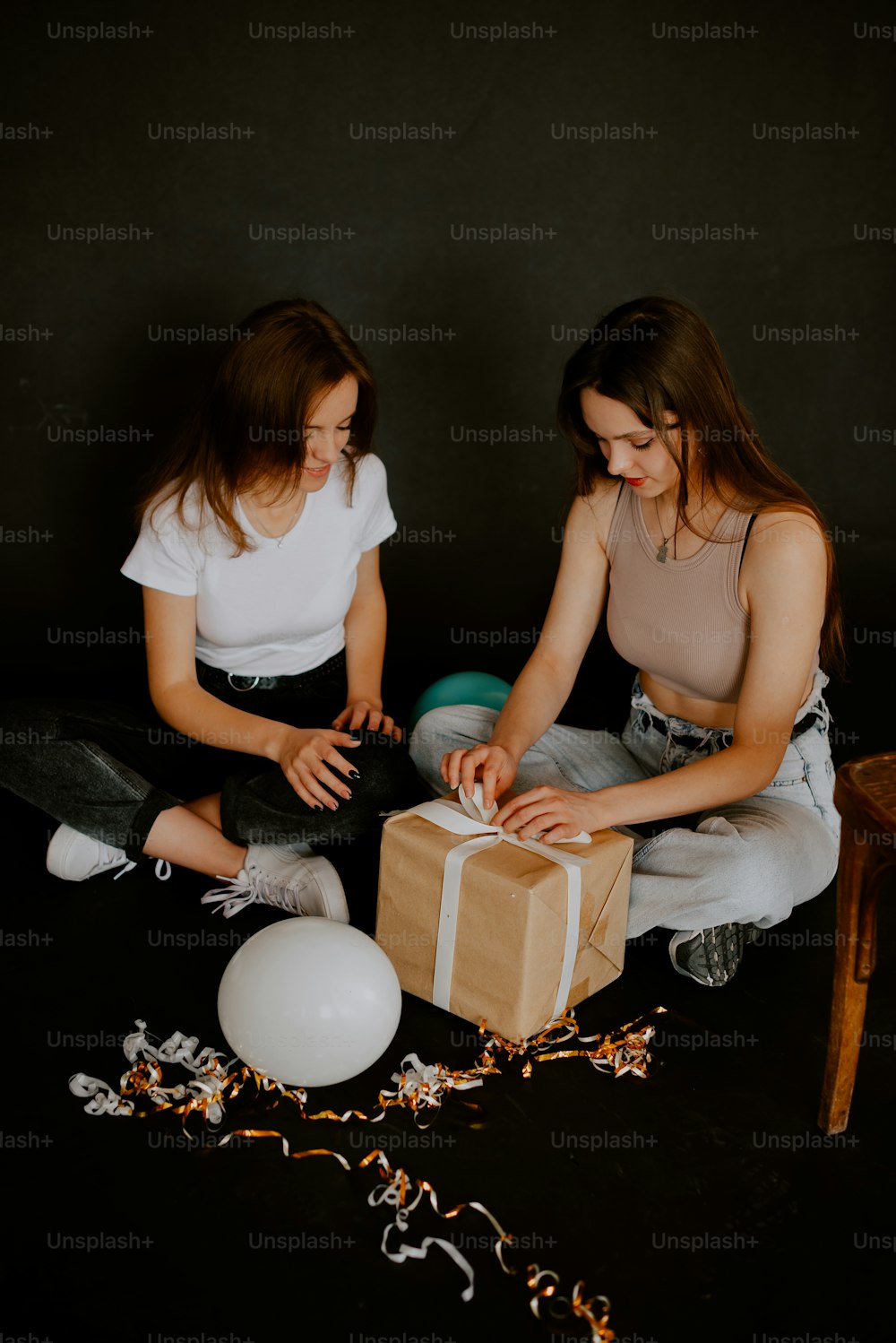 선물을 들고 바닥에 앉아 있는 두 소녀