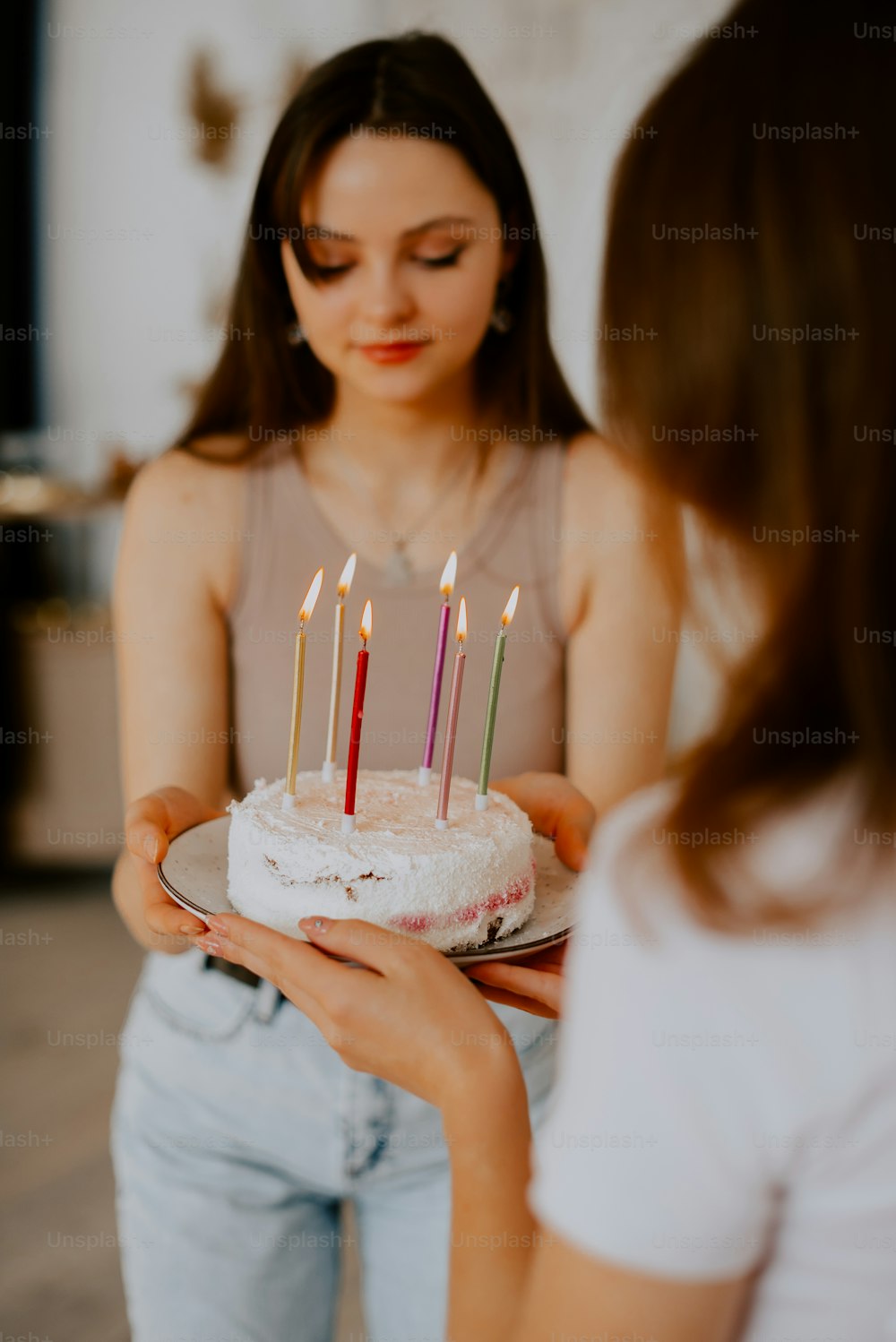 a woman holding a cake with candles on it