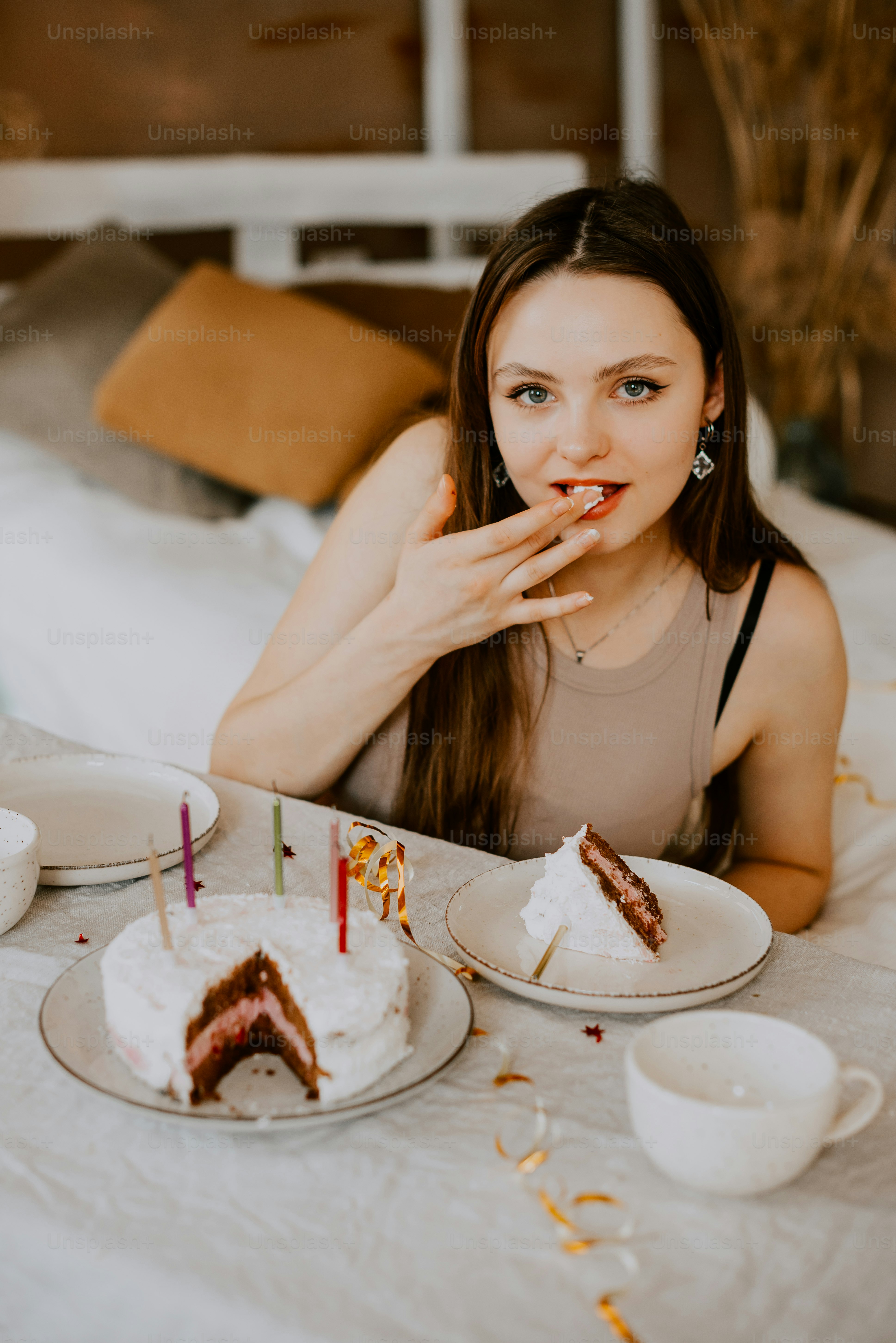 a woman sitting at a table with a slice of cake in front of her