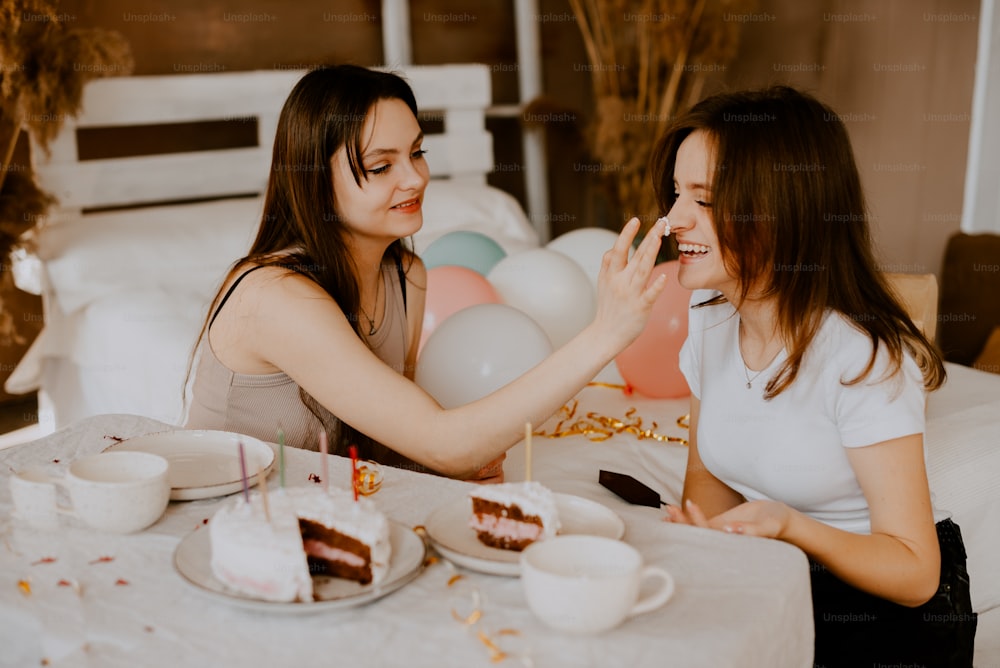 Deux femmes assises à une table en train de manger du gâteau