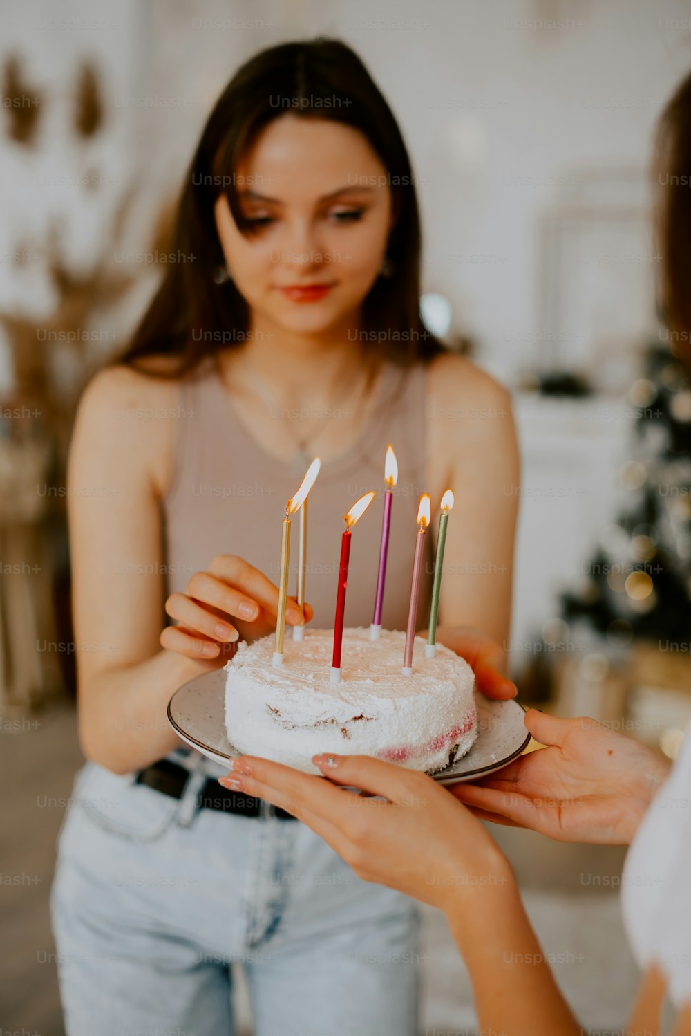 uma mulher segurando um bolo com velas sobre ele