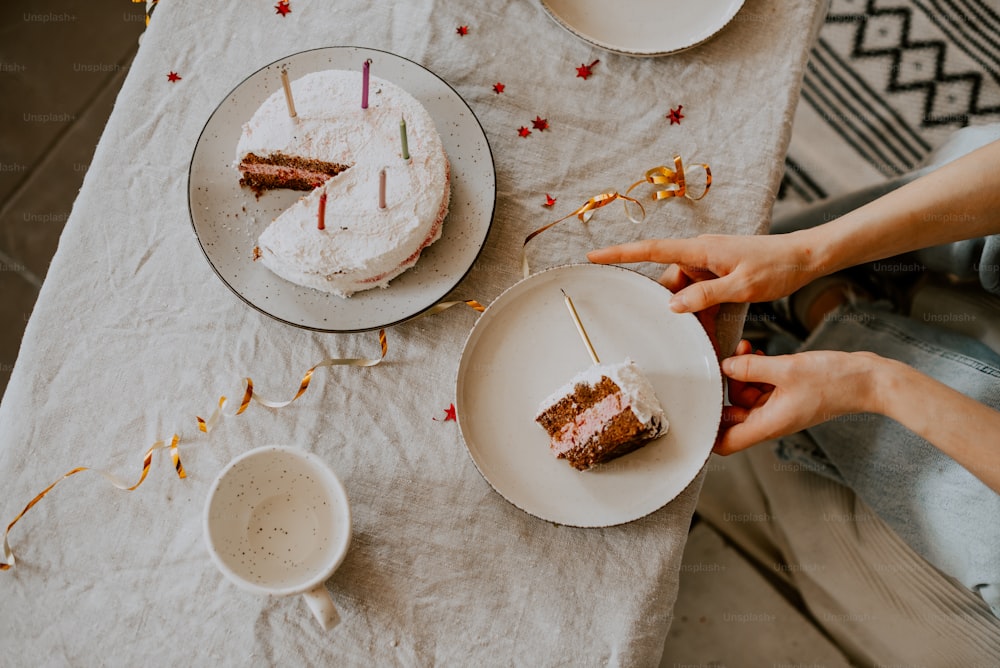 a person cutting a piece of cake on a table