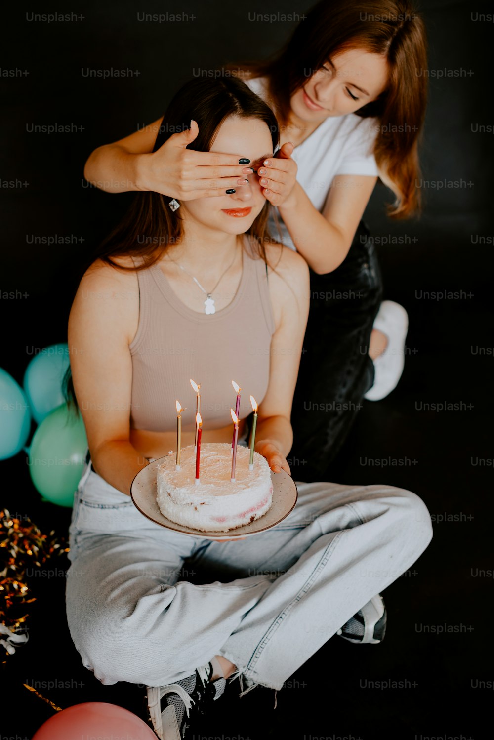 촛불이 달린 케이크 앞에 앉아 있는 여자