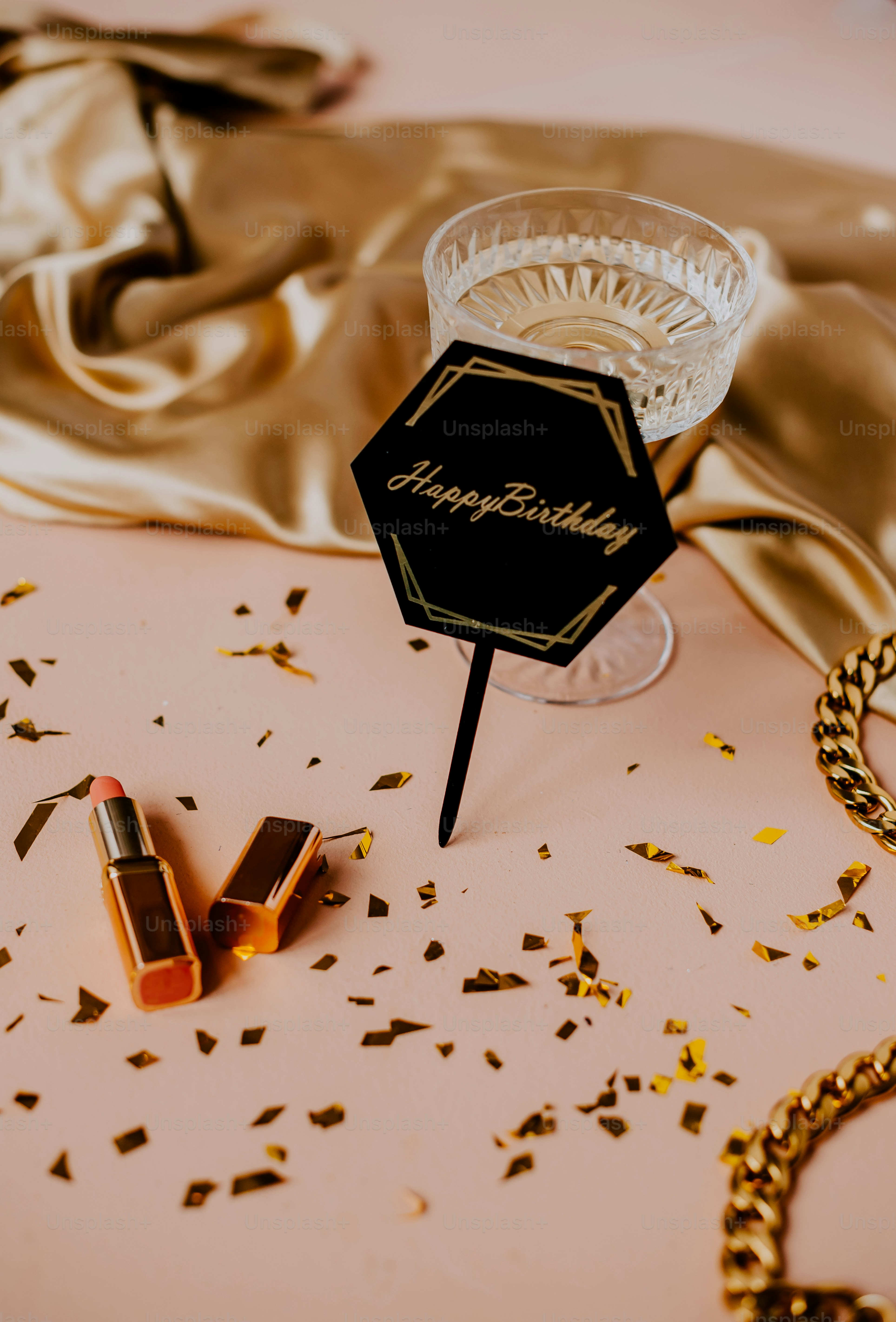 a table topped with a bottle of liquid and a pair of lipstick