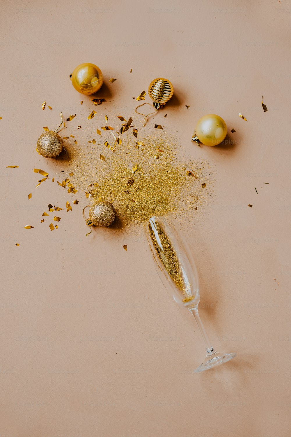 a glass filled with gold glitter next to some eggs