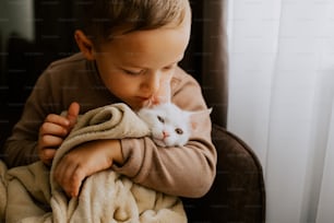 Un niño pequeño que sostiene un gato