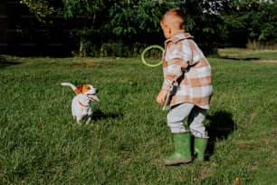 풀밭에서 개와 놀고 있는 어린 소년