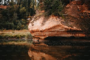 a body of water with a large rock in the middle of it