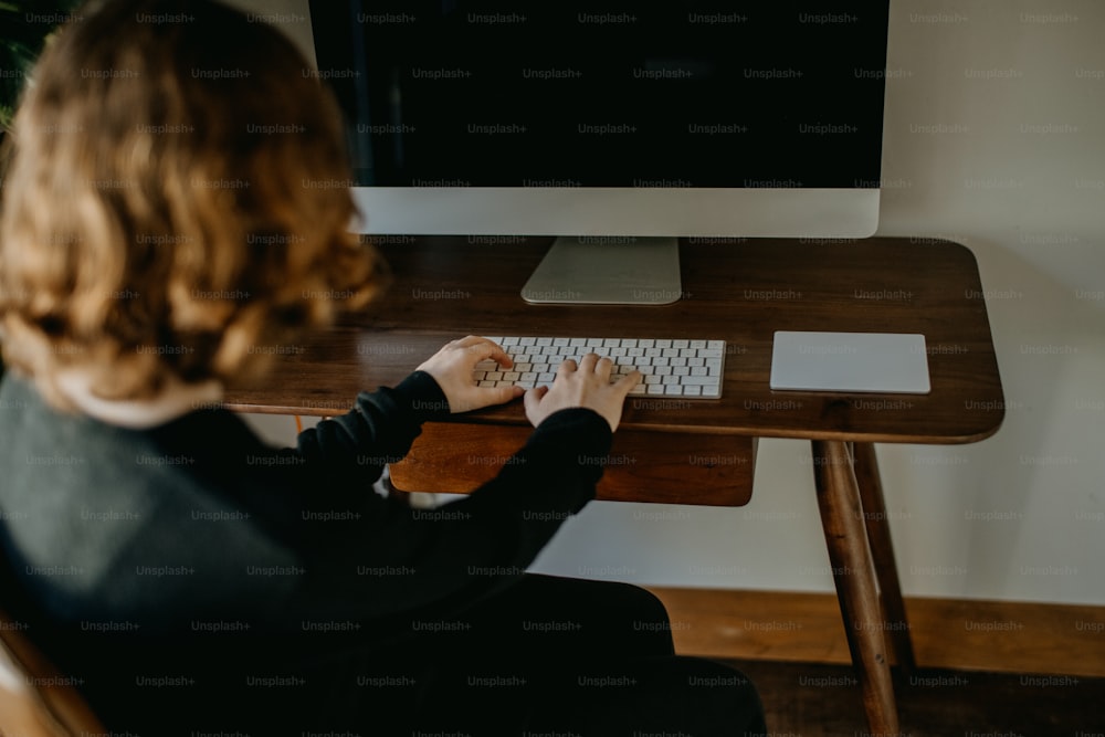 a woman sitting at a desk with a keyboard and mouse