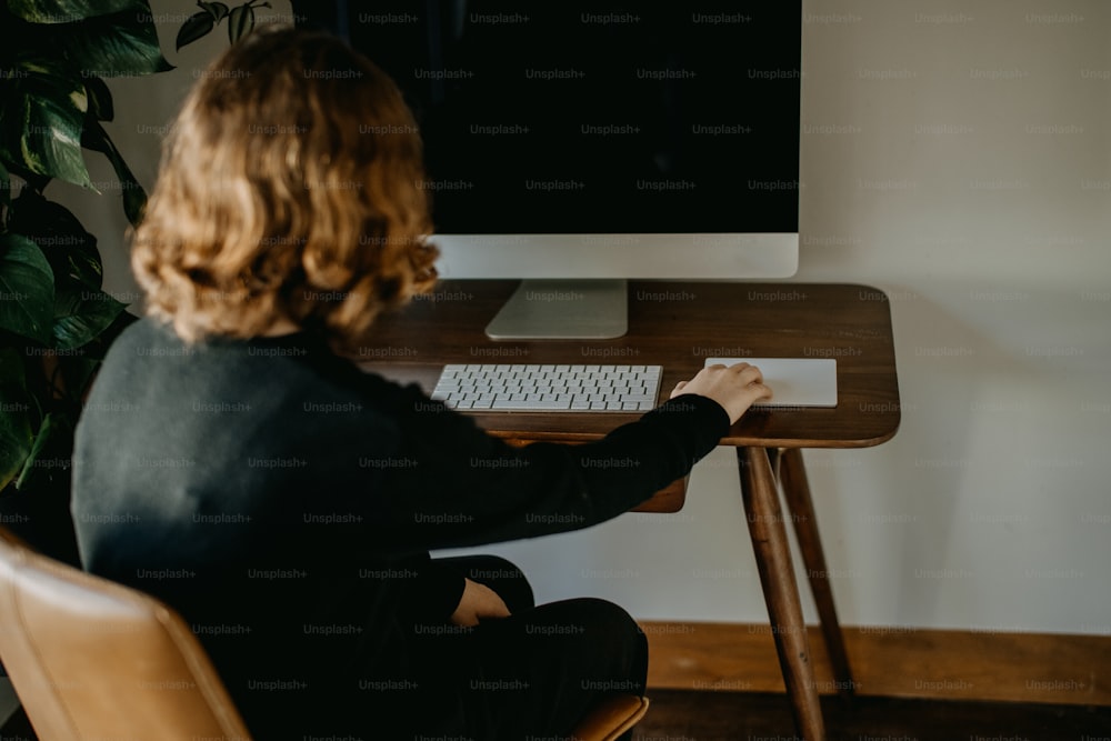 uma mulher sentada em uma mesa com teclado e mouse
