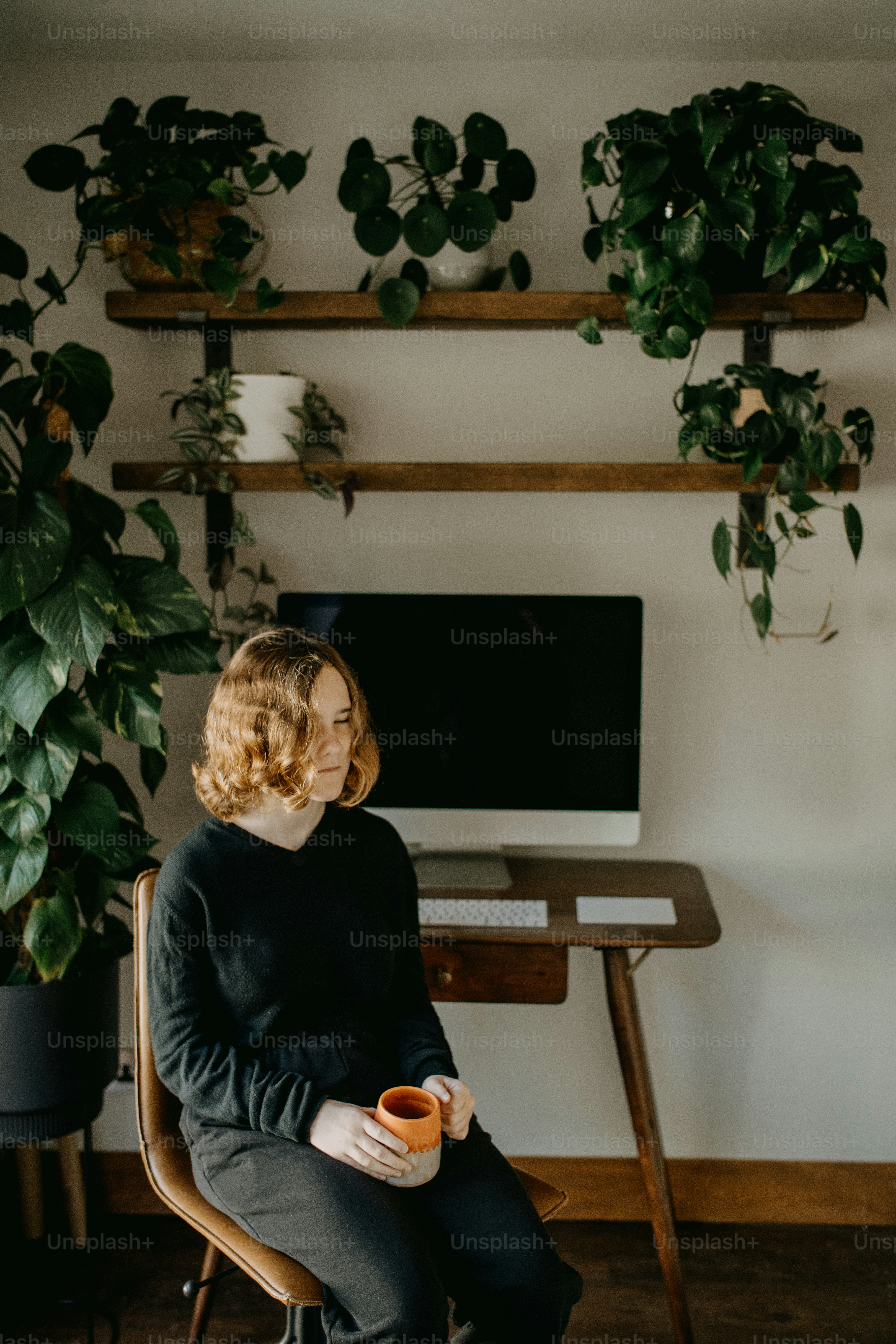 Eine Frau, die auf einem Stuhl vor einem Fernseher sitzt