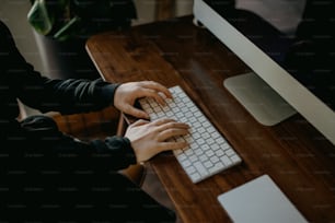 a person typing on a keyboard at a desk