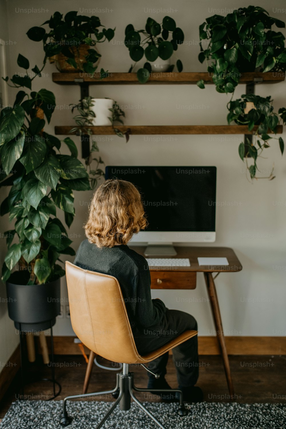 a person sitting at a desk in front of a computer