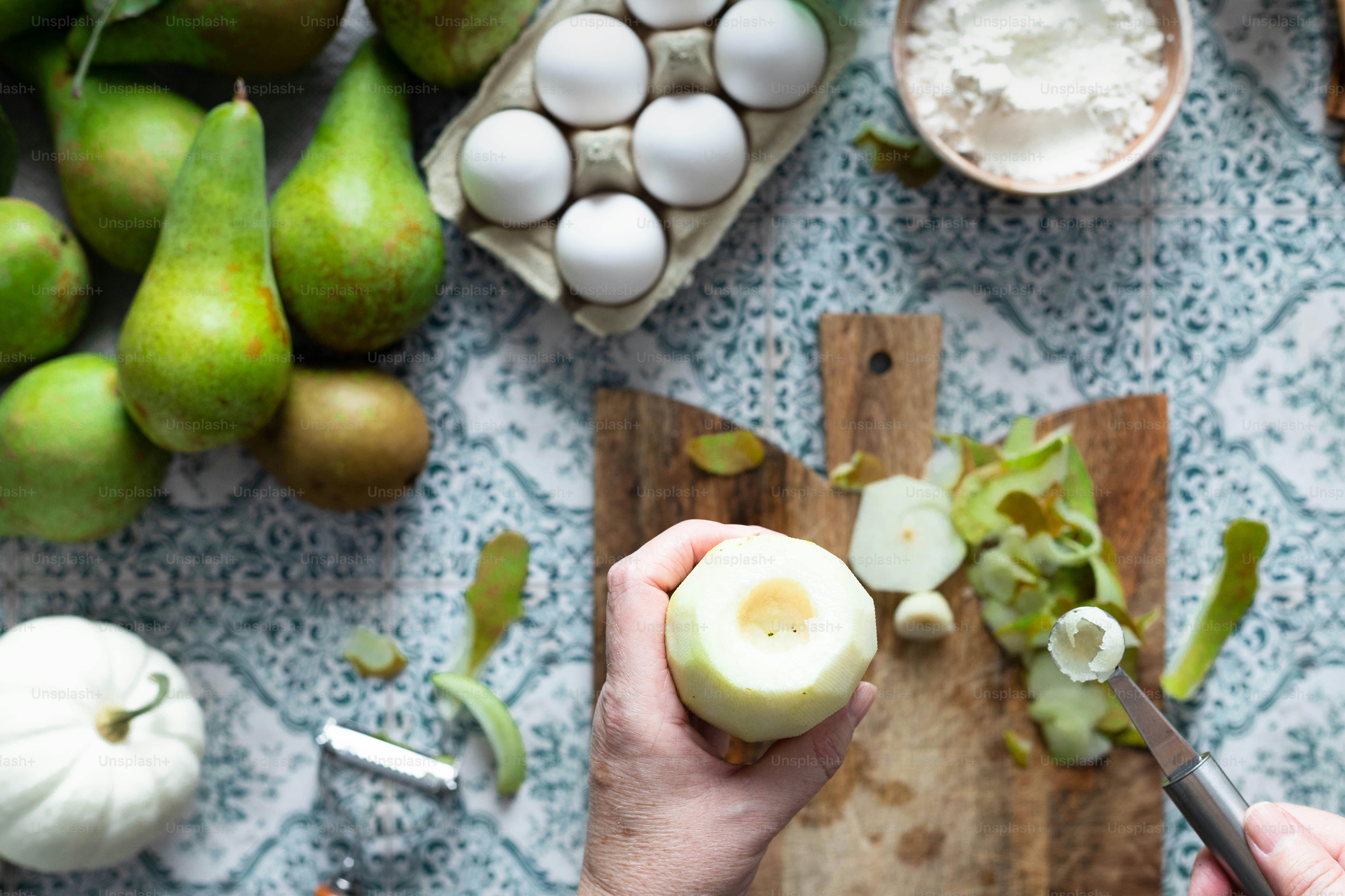 a person cutting an apple on a cutting board