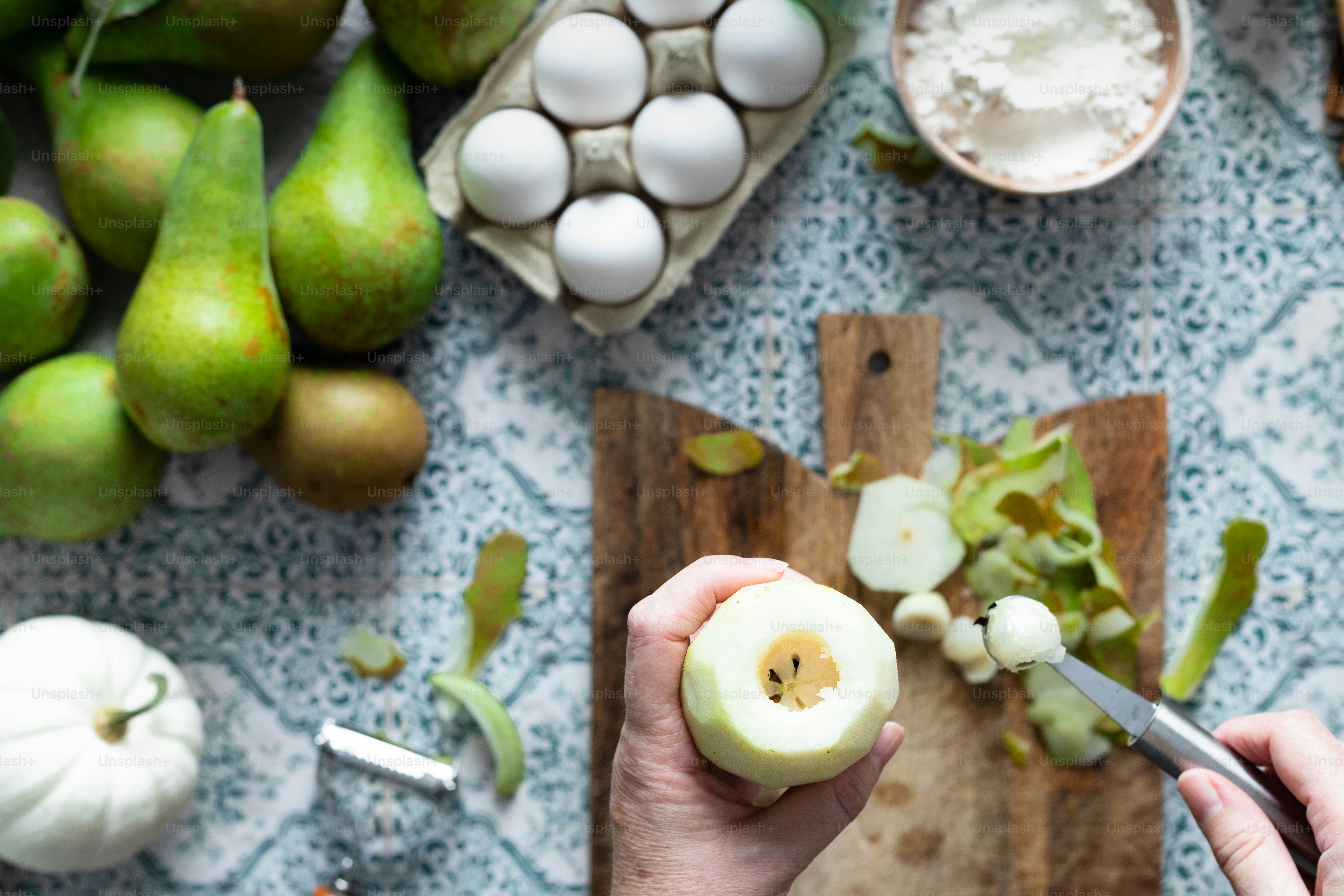 a person cutting an apple on a cutting board