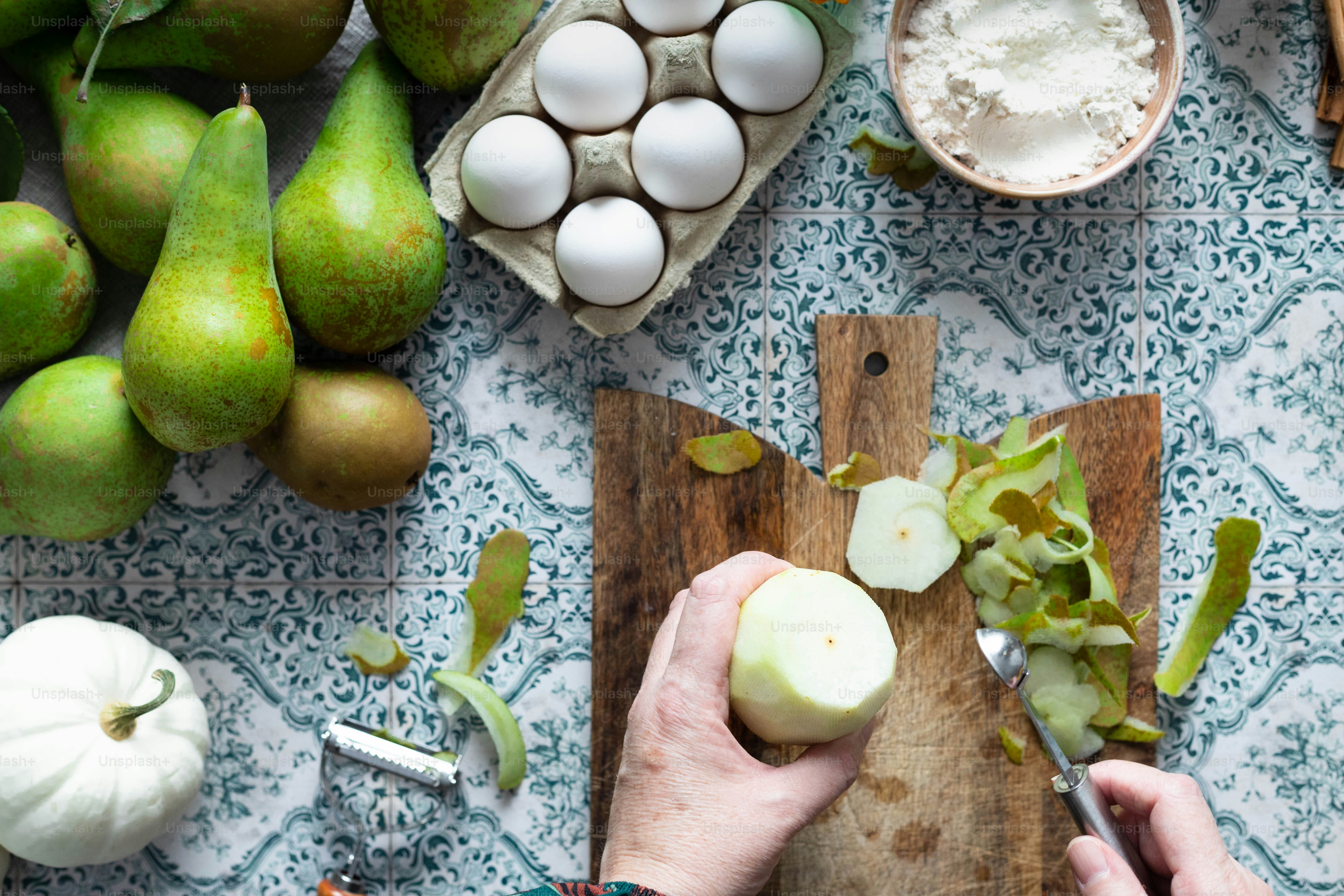 a person cutting an apple on a cutting board