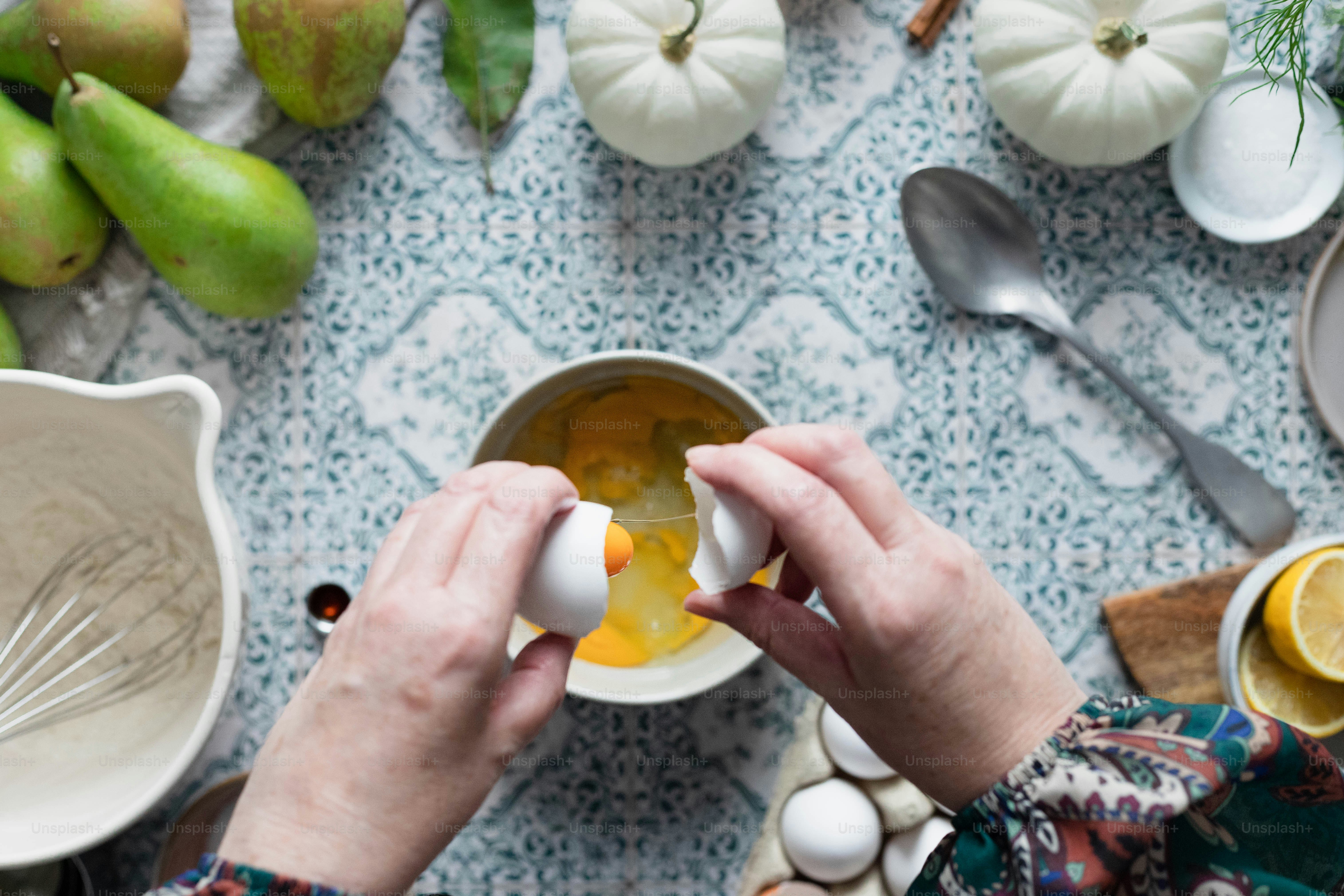 a person holding an egg in front of a bowl of eggs