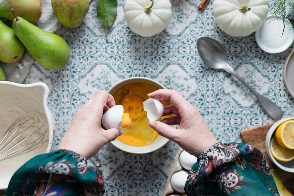 a person is peeling an egg into a bowl