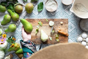 a person cutting up a pear on a cutting board