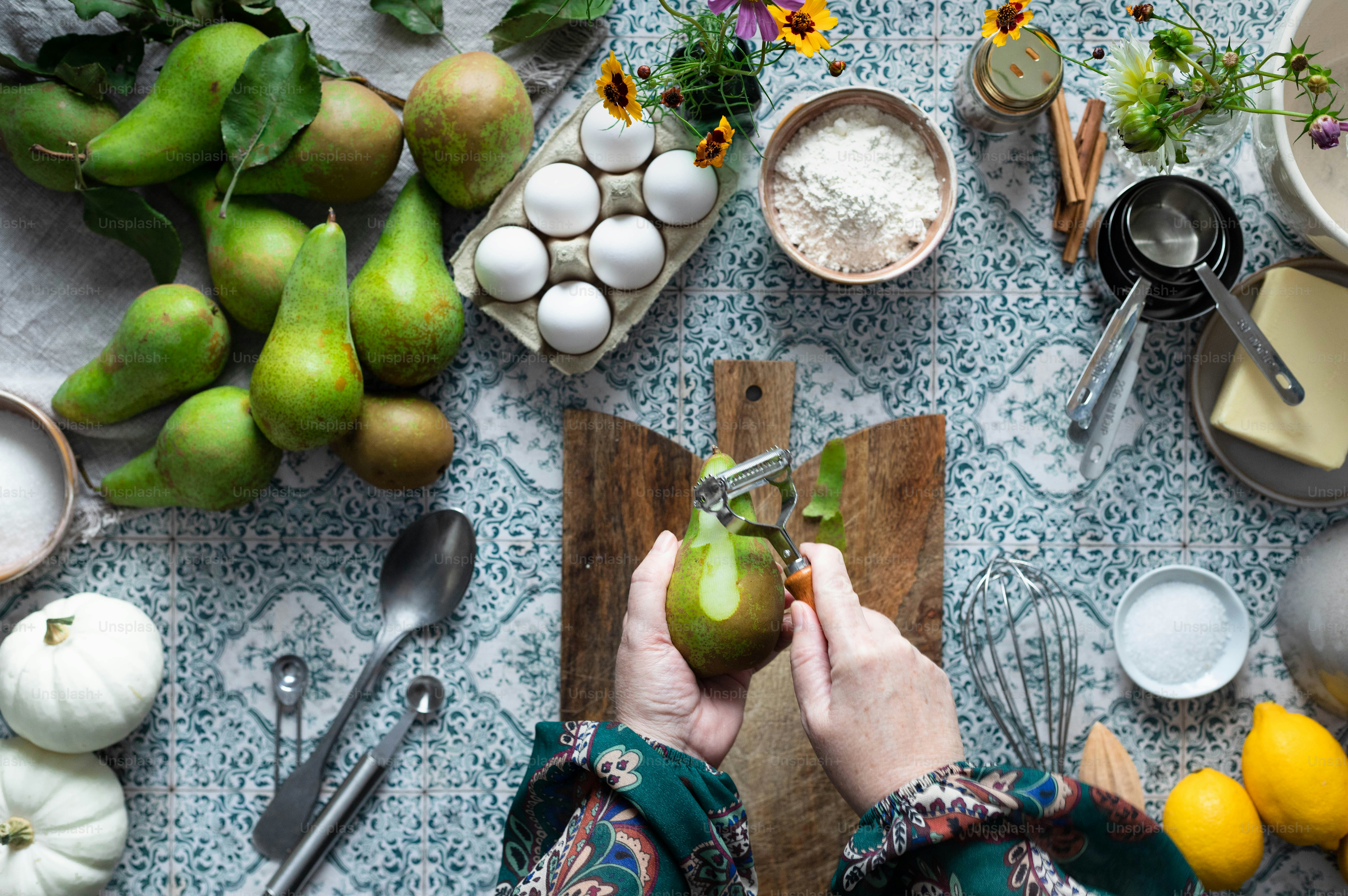 a person cutting a pear on a cutting board