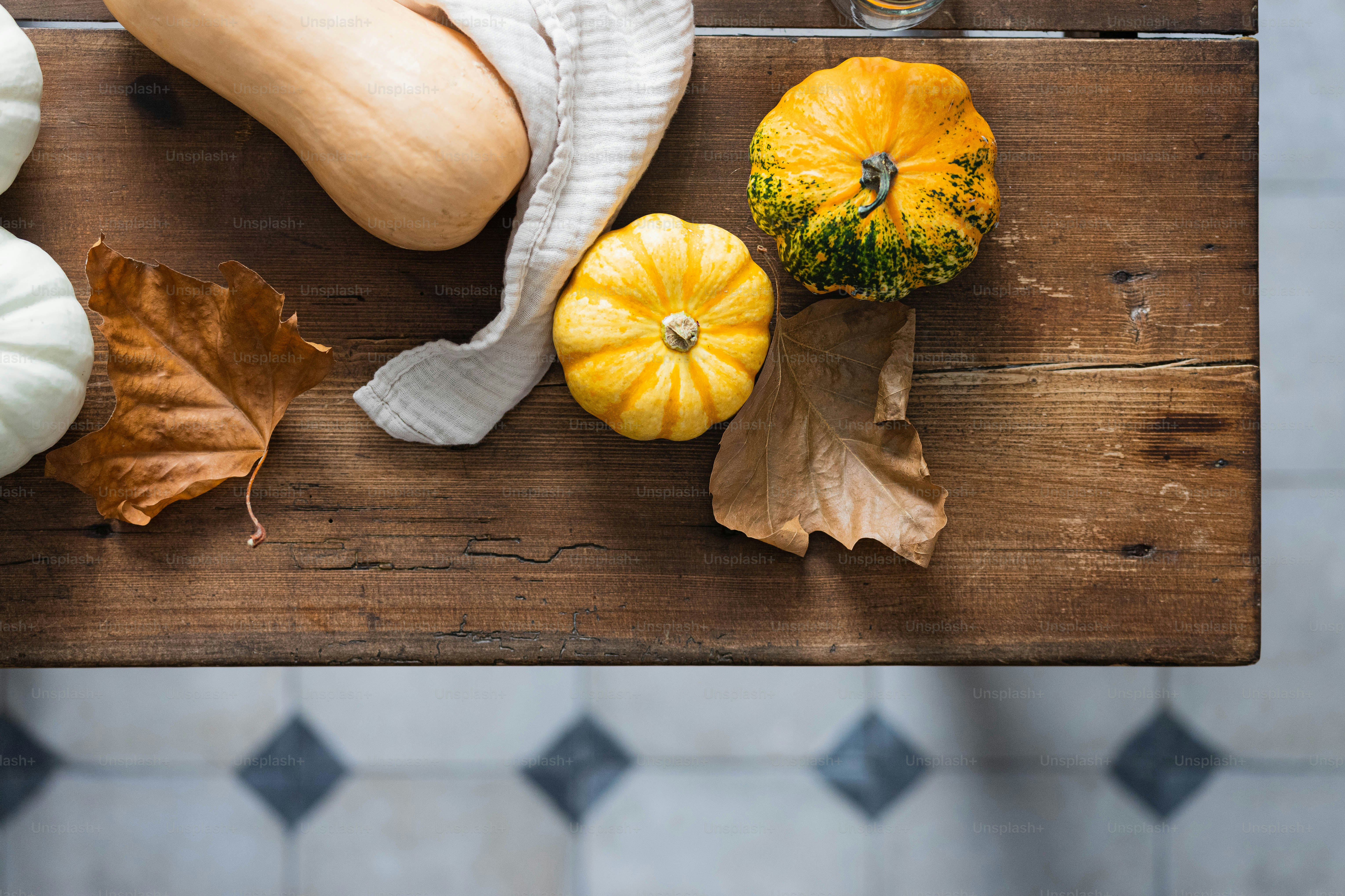 Un tavolo di legno sormontato da molti tipi diversi di zucche