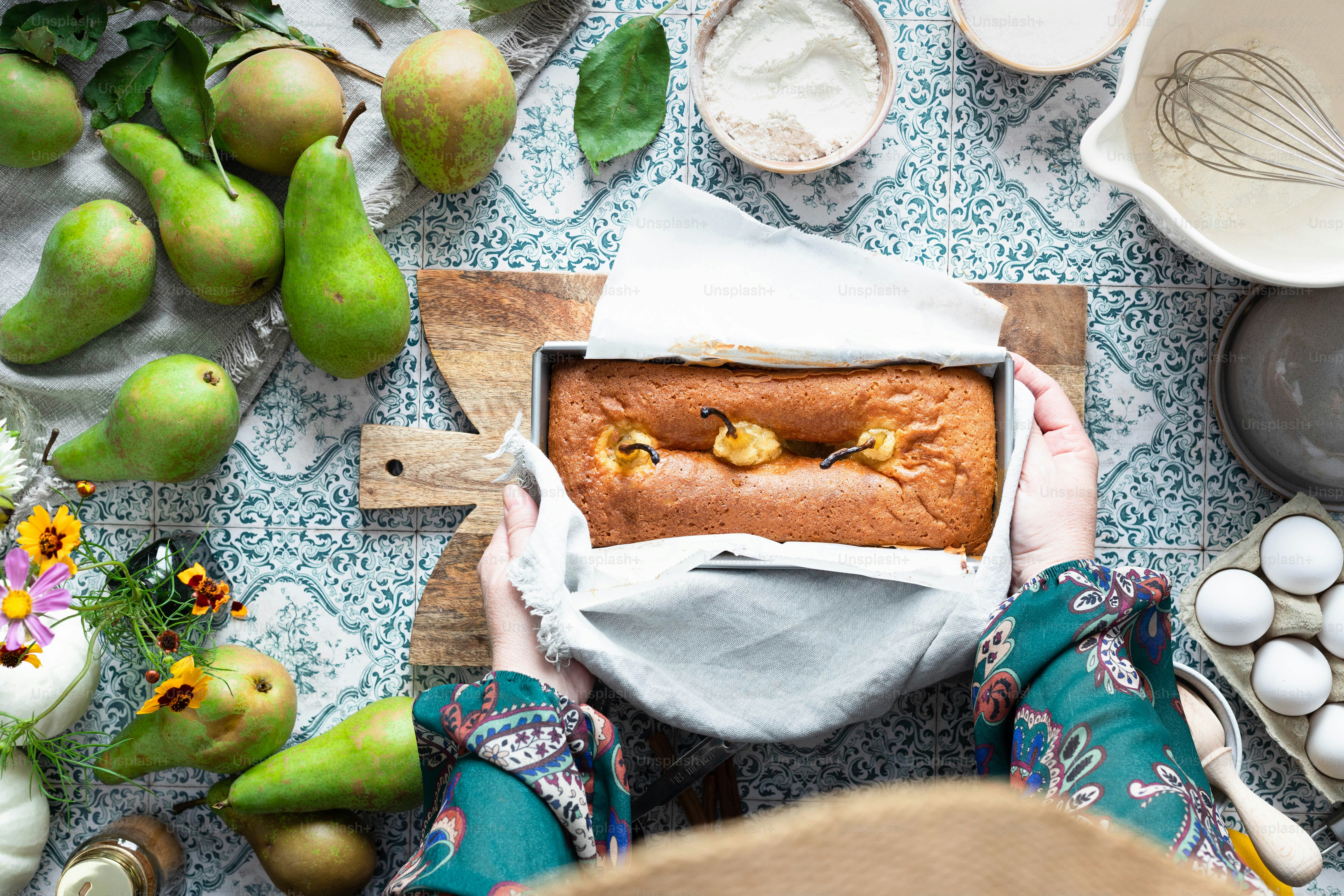una persona che tiene una pagnotta di pane sopra un tavolo