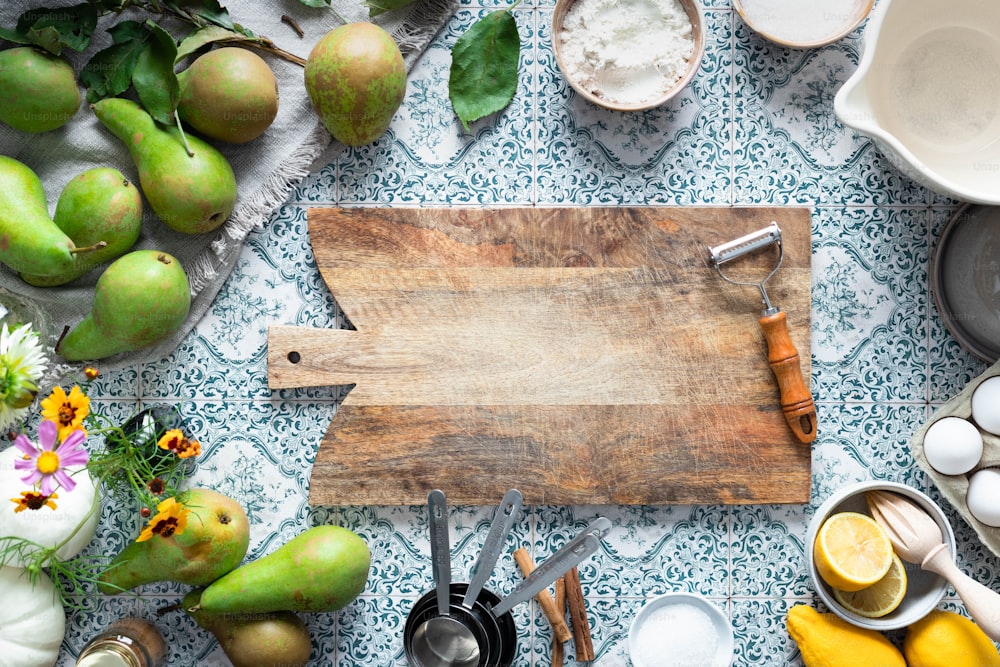 a wooden cutting board surrounded by various kitchen utensils