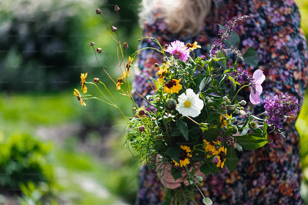 a woman holding a bouquet of flowers in her hands