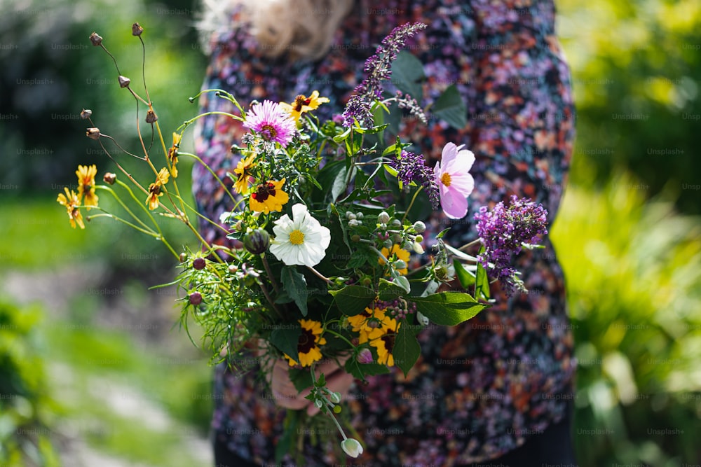 a woman holding a bouquet of flowers in her hands