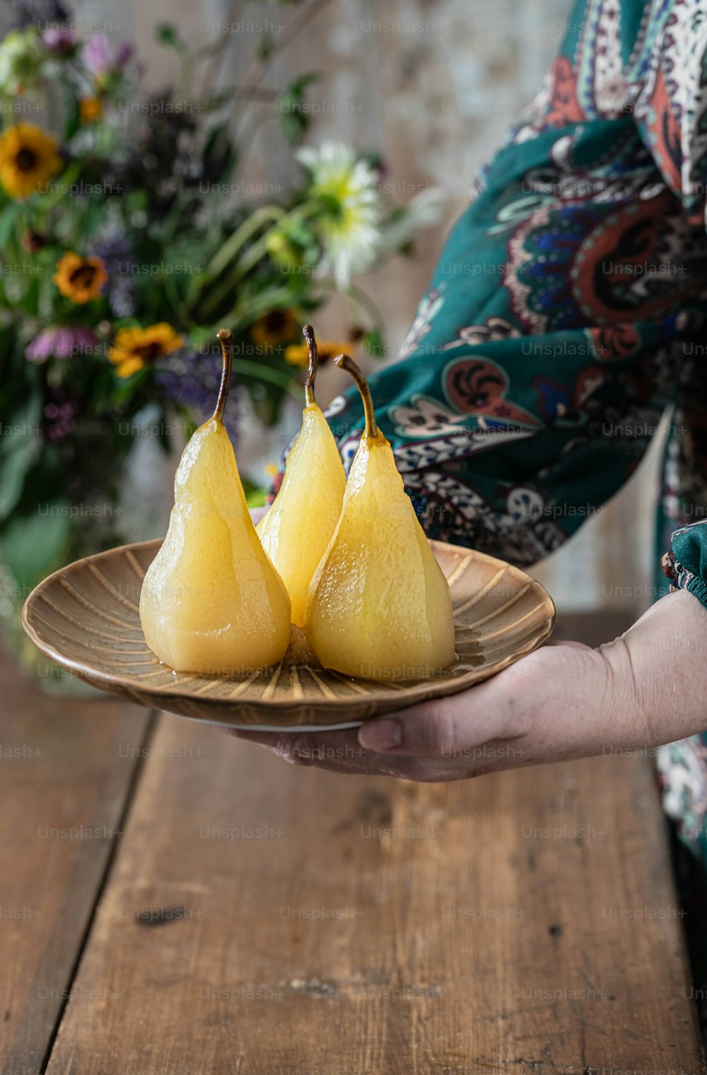 a person holding a plate with two pears on it