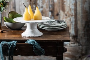 uma mesa de madeira coberta com pratos e peras