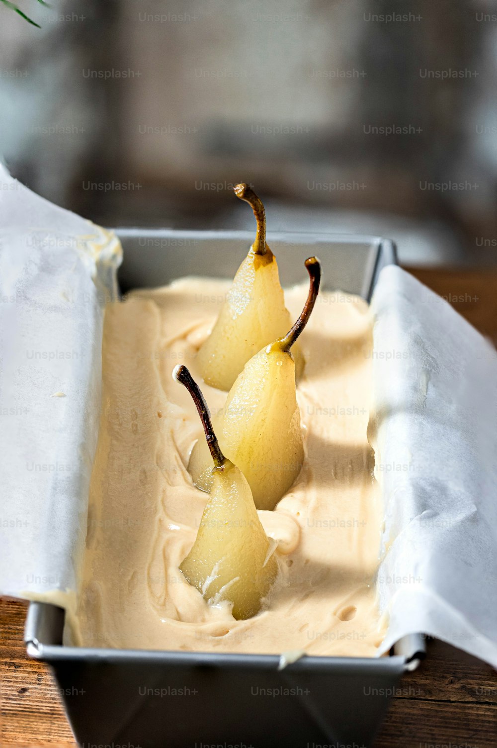three pears in a metal container on a table