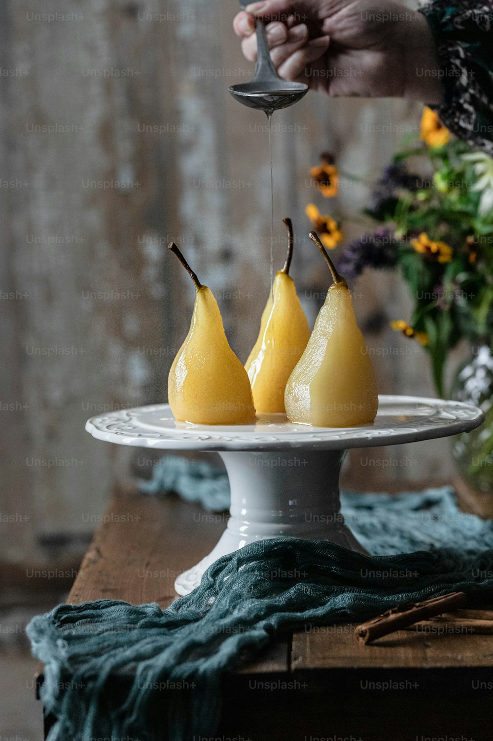 テーブルの上に3つの梨をトッピングした白い皿